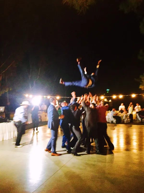 Guests lifting a friend high into the air on a night-time dance floor