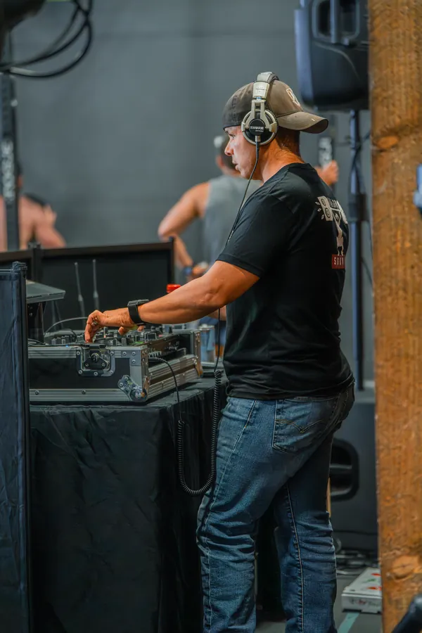 Hector at the booth during a fitness competition, the Valor Sound print on the back of his tee
