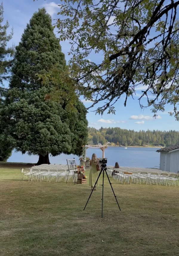Lakeside ceremony with a speaker on a stand beside the aisle