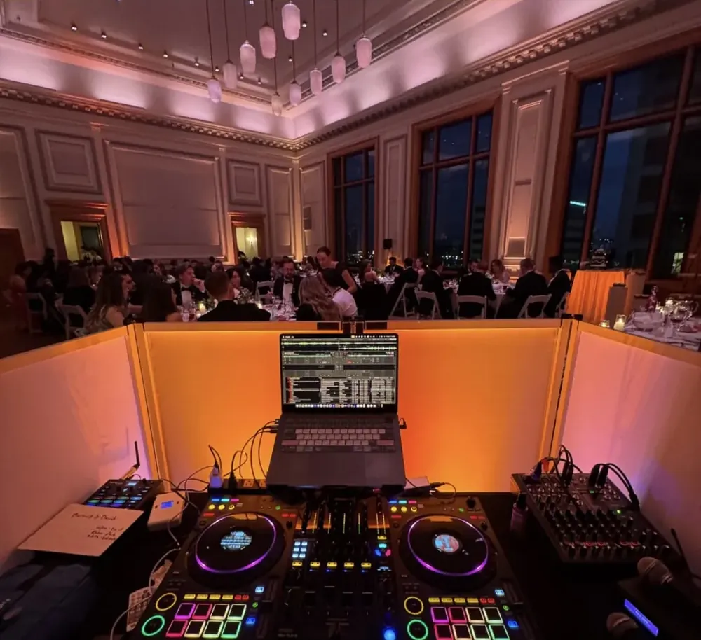 White booth facade in a black-tie ballroom with warm uplighting